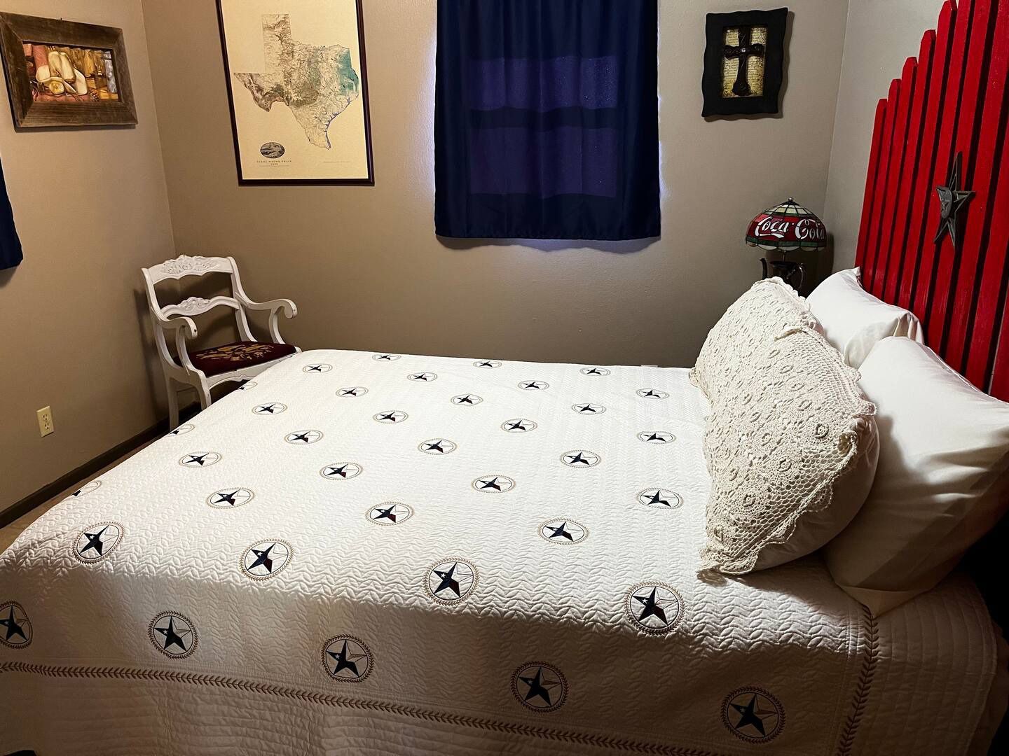 A bedroom with a king size bed and a red headboard