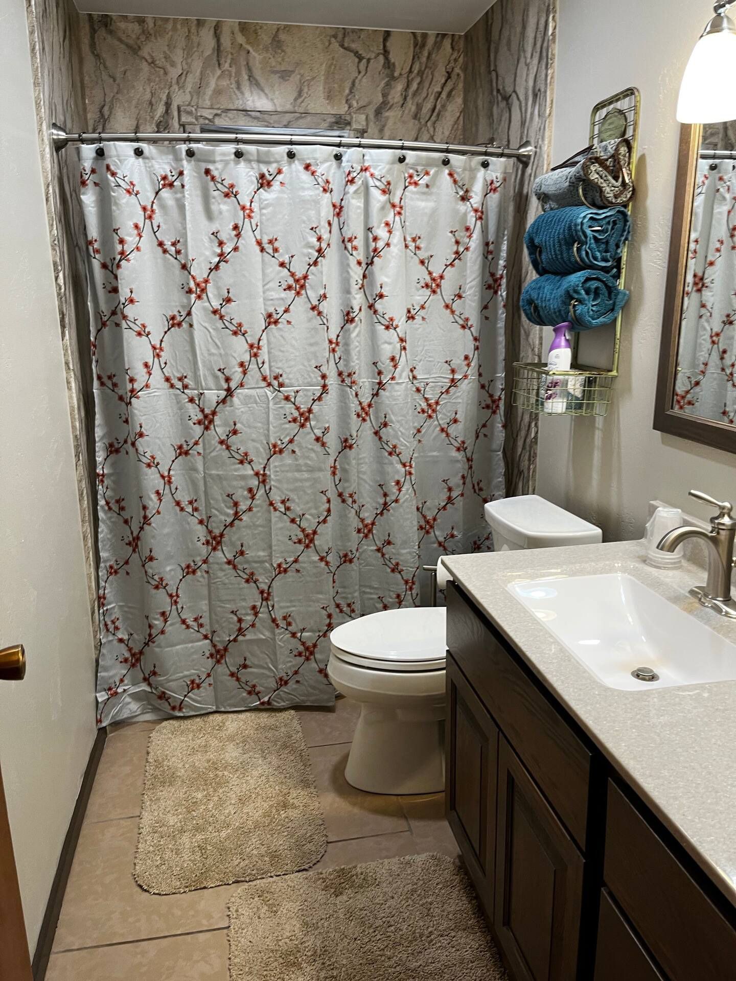 A bathroom with a toilet , sink , and shower curtain.