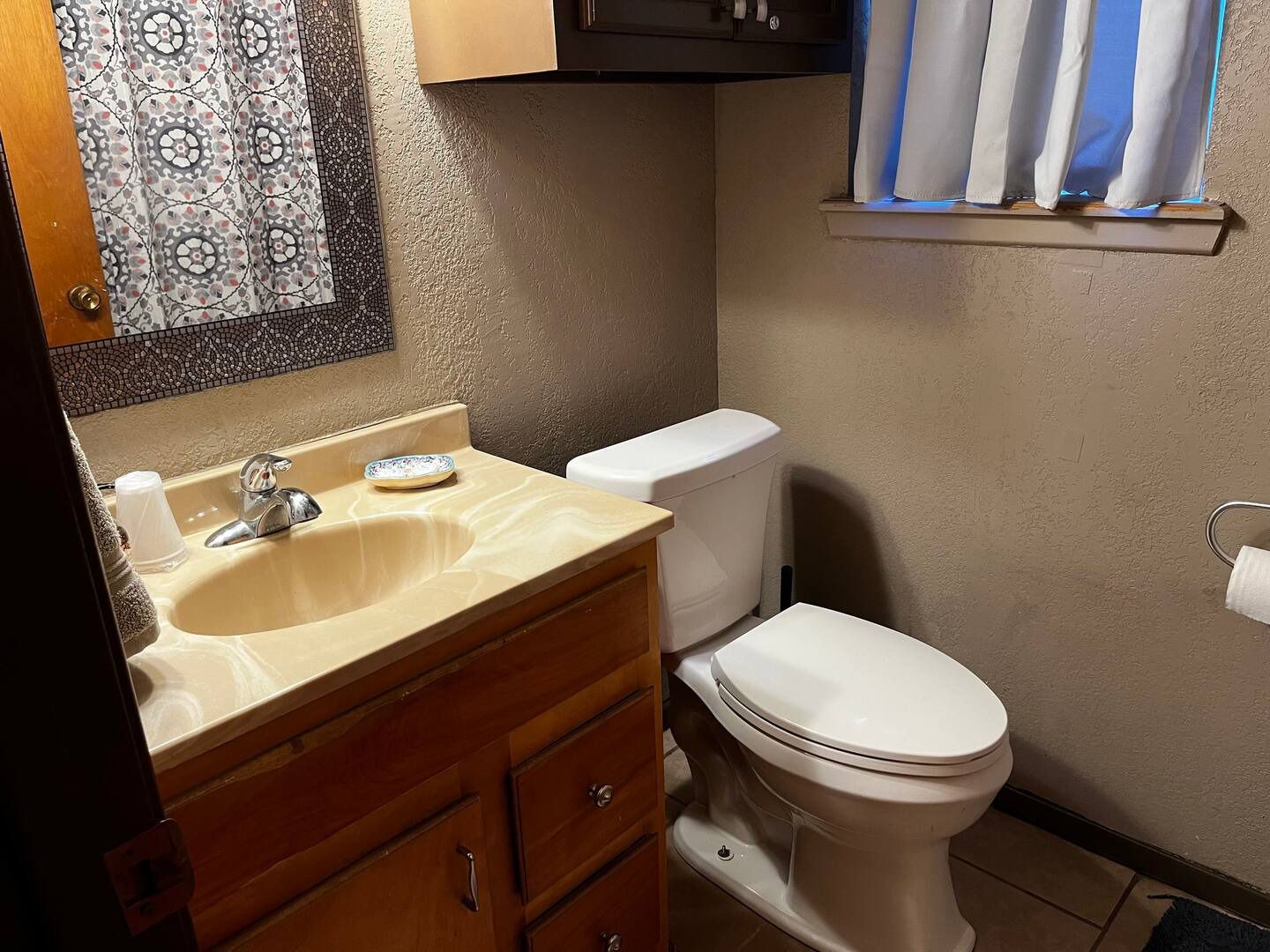A bathroom with a toilet , sink and mirror