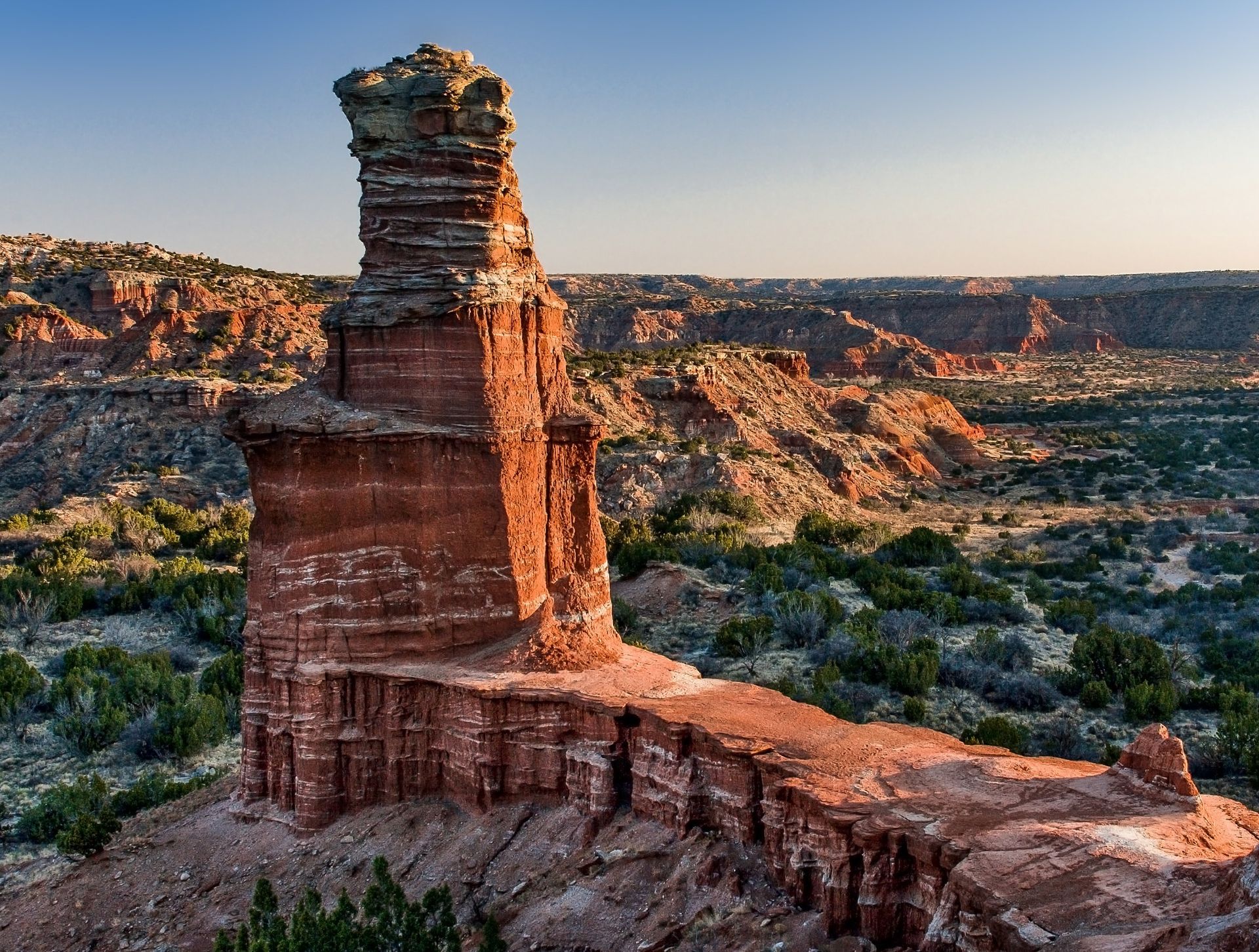A large rock formation in the middle of a desert.