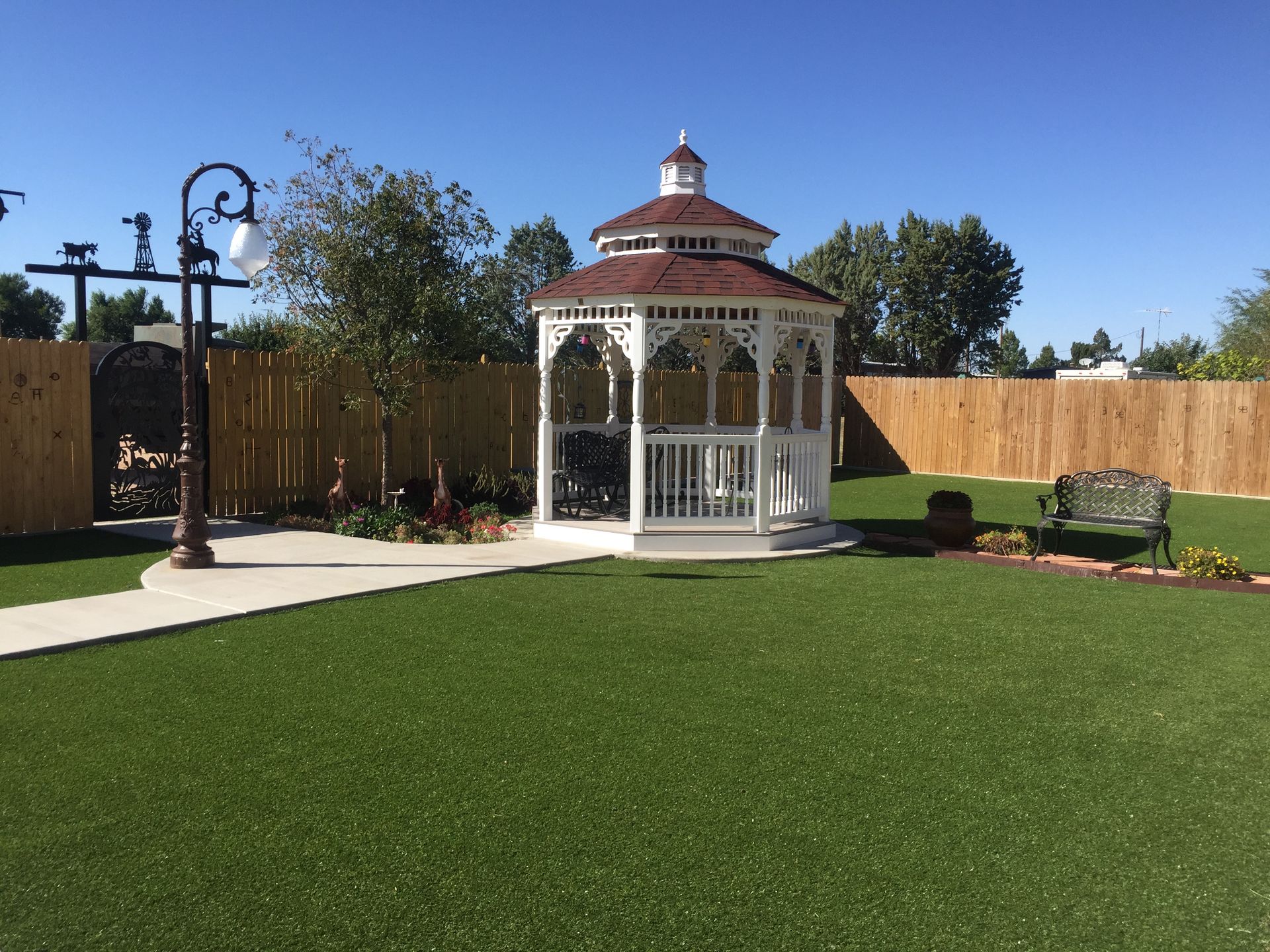 A white gazebo is sitting on top of a lush green lawn.
