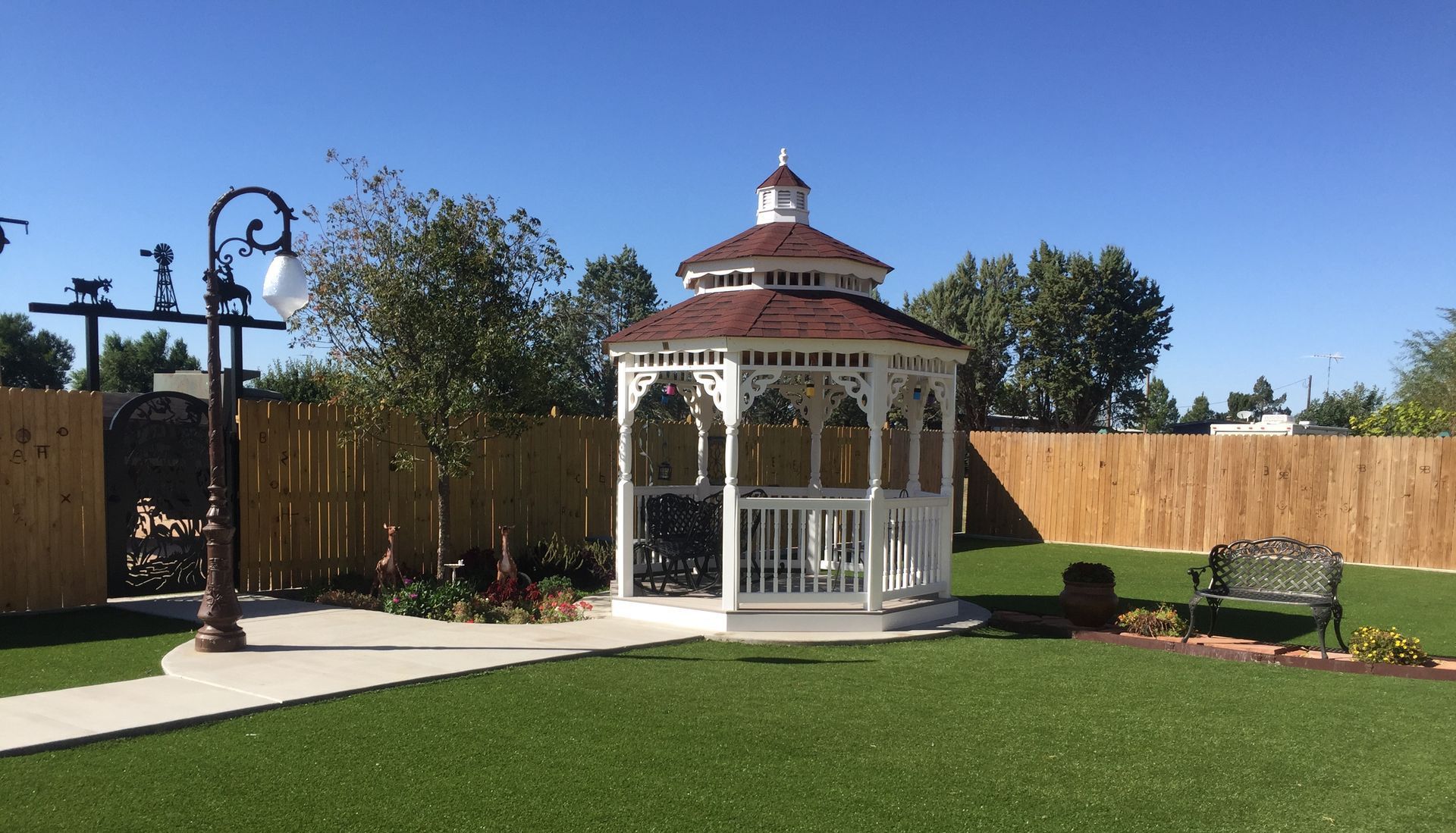 A white gazebo is sitting on top of a lush green lawn.