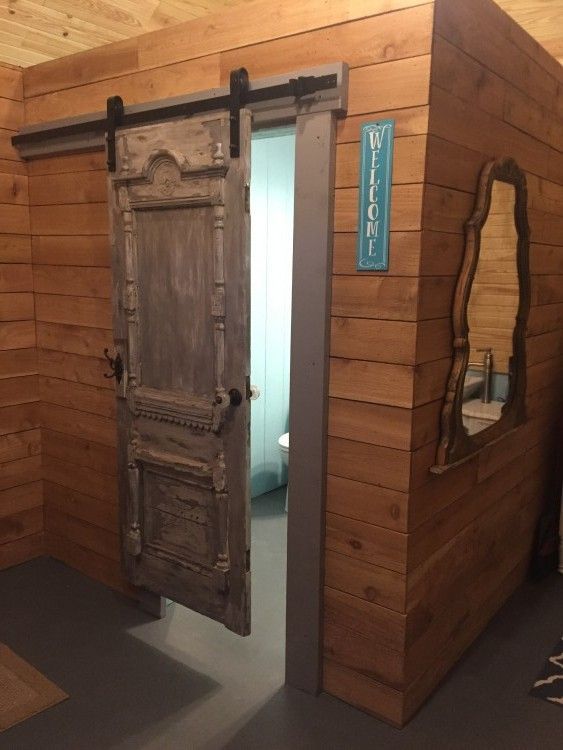 A bathroom with a sliding barn door and a mirror
