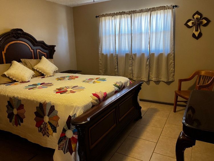 A bedroom with a king size bed and a chair