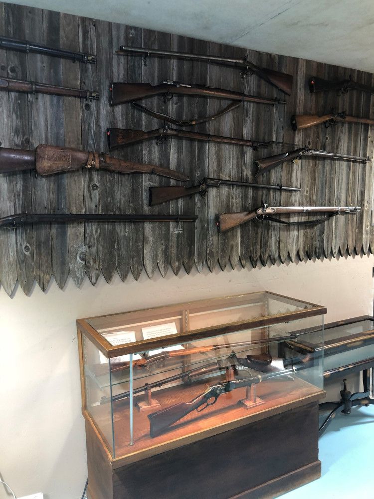 A room with rifles attached on the wall.