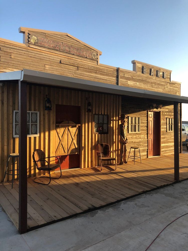 A wooden building with a porch and chairs in front of it