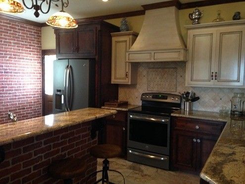 A kitchen with stainless steel appliances and a brick wall