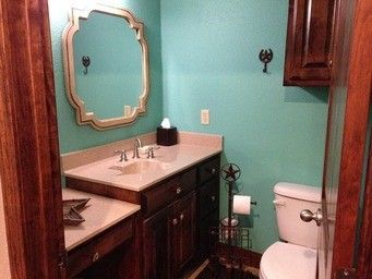 A bathroom with a sink , toilet and mirror.