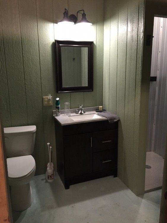 A bathroom with a toilet a sink and a mirror