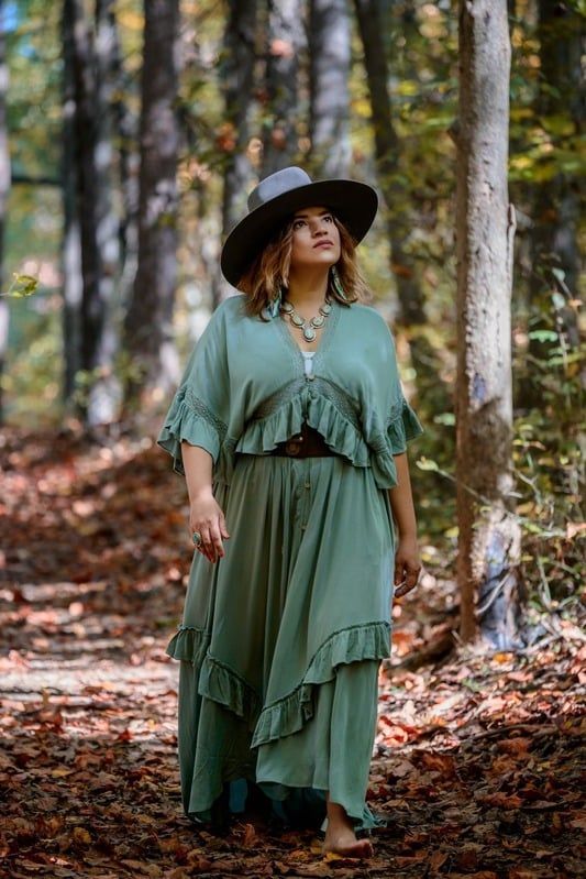 A woman is holding another woman 's hand while sitting on a couch.