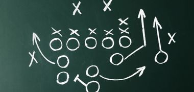 A chalkboard with a football play drawn on it.