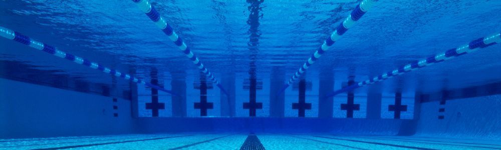 A person is swimming in a swimming pool underwater.