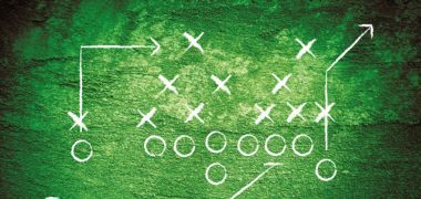 A drawing of a football play on a green background.