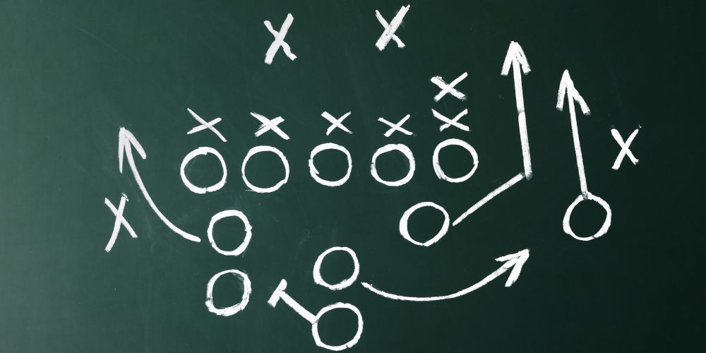 A chalkboard with a football strategy drawn on it