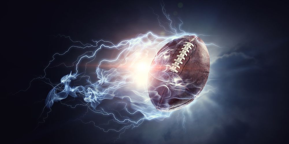 American football with lightning emanating from it, against a dark background.