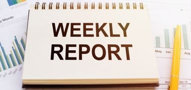 A notebook with the words `` weekly report '' written on it.
