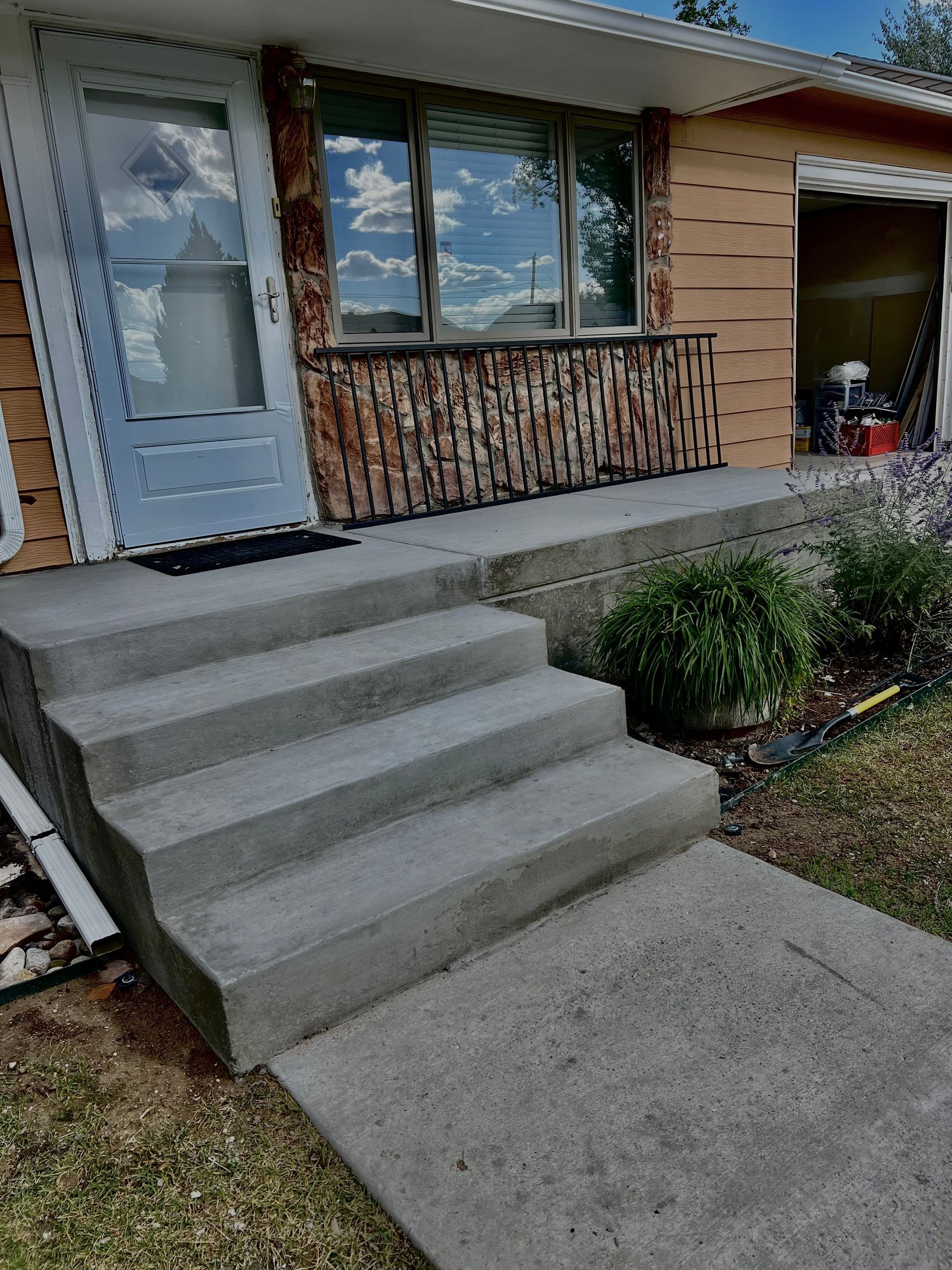 A house with concrete steps leading up to the front door.
