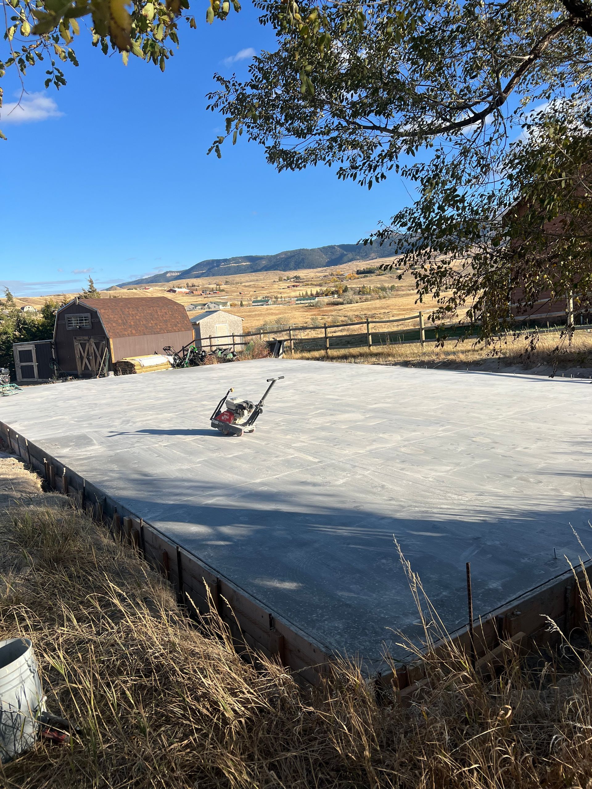 A lawn mower is sitting on top of a concrete driveway.