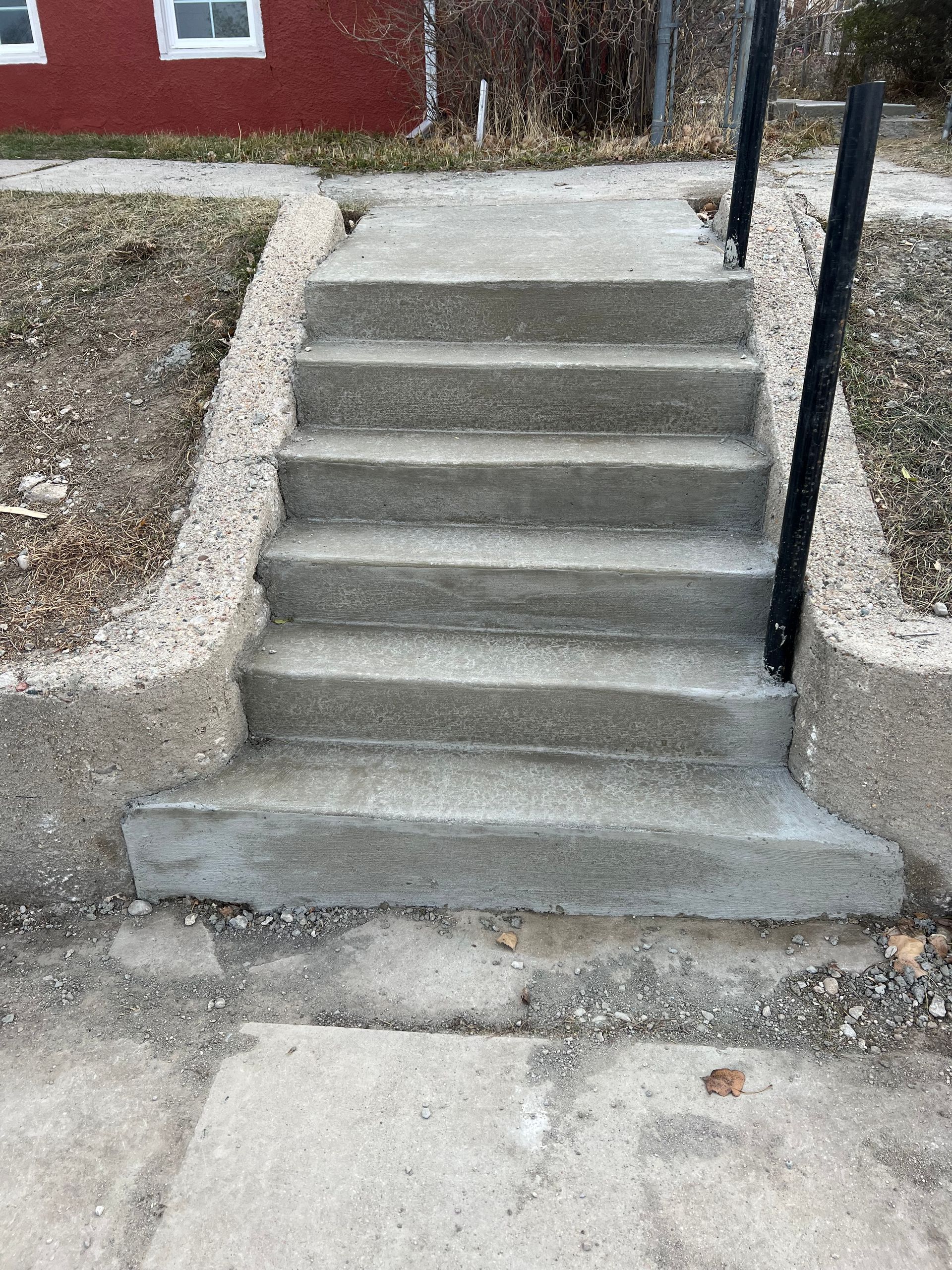 A set of concrete stairs leading up to a house.