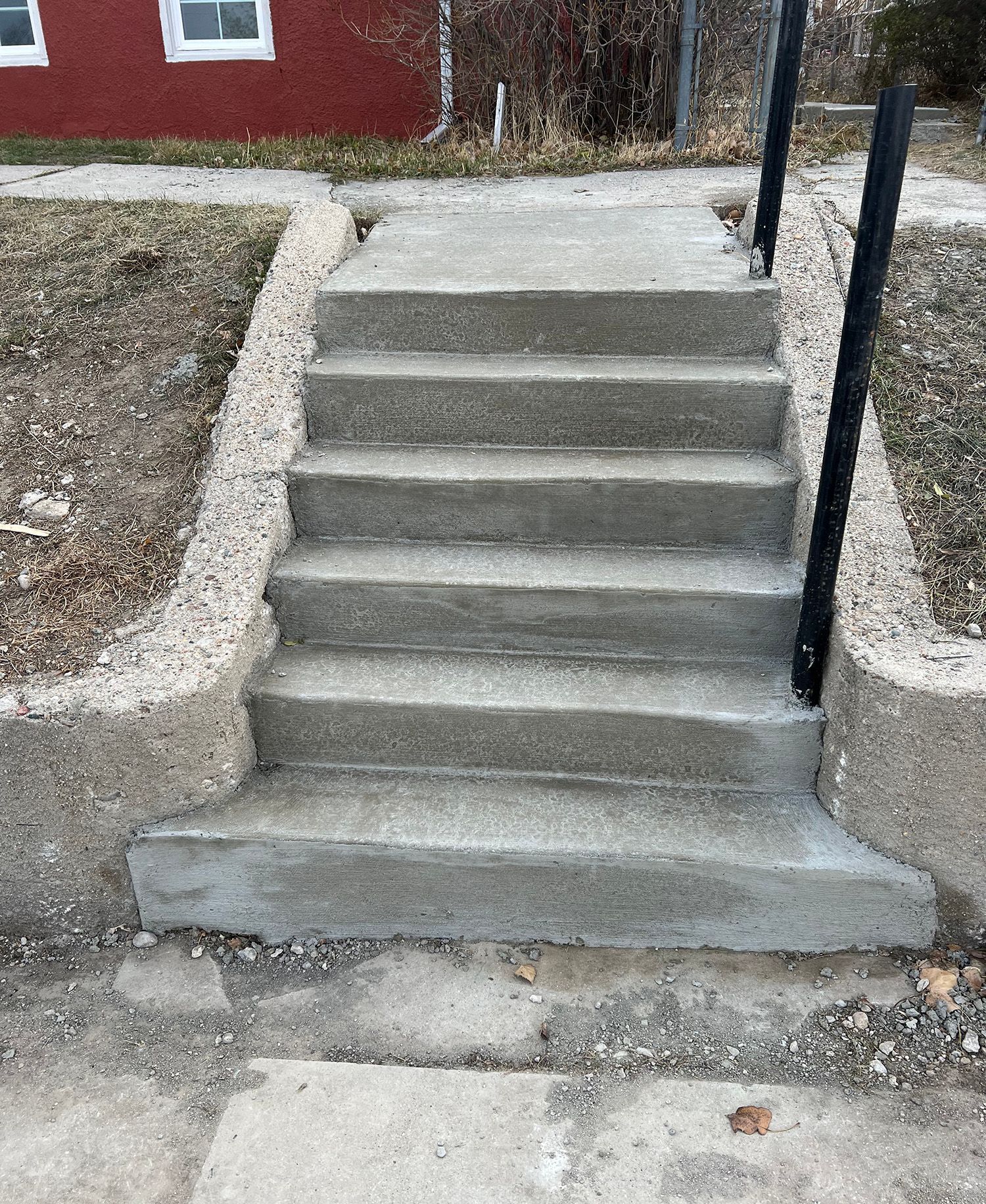 A set of concrete stairs leading up to a house.