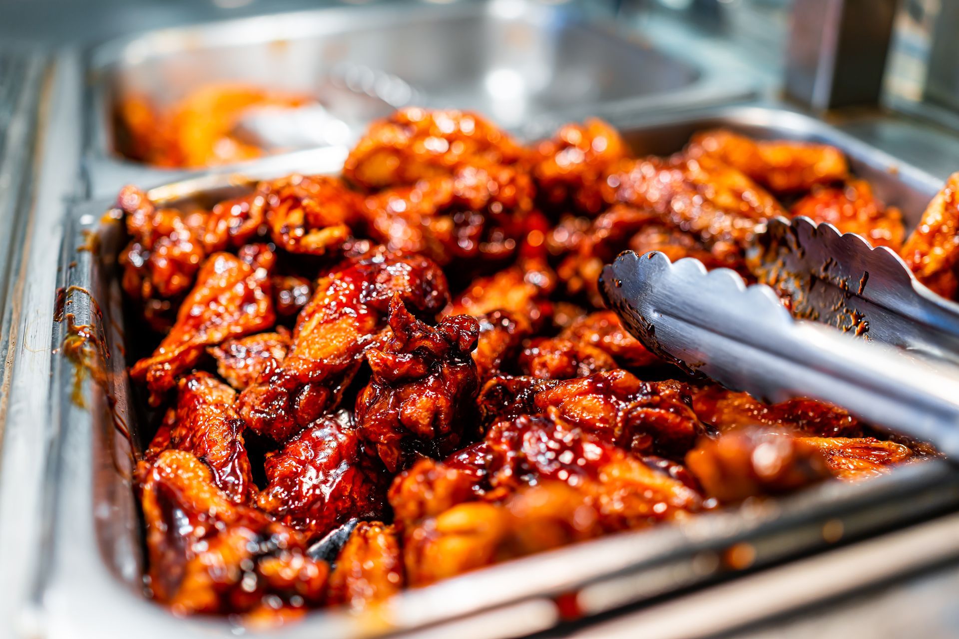 A close up of a tray of food with tongs