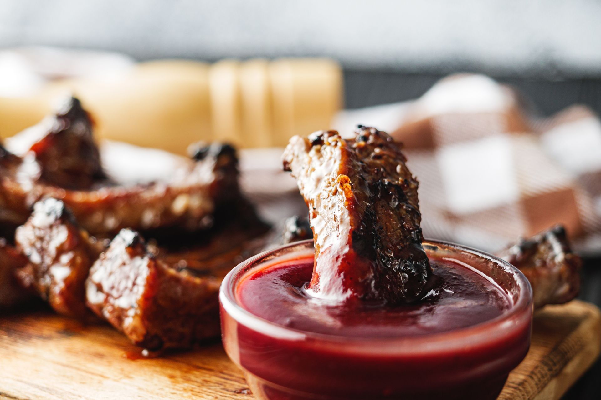A piece of meat is sticking out of a bowl of barbecue sauce
