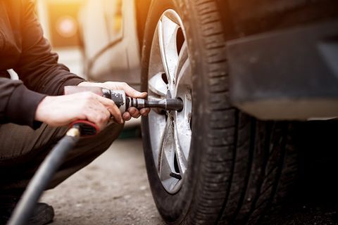Tire Repairs — Auto Mechanic Man with Electric Screwdriver Changing Tire in Cornersville, TN
