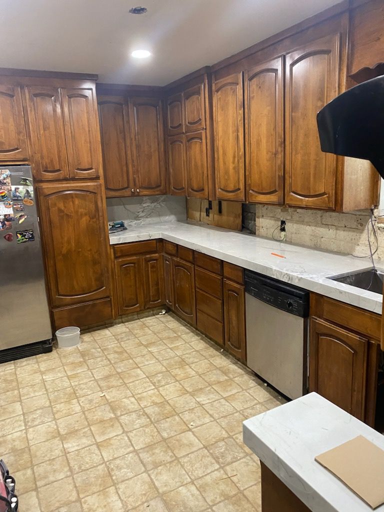 a kitchen with wooden cabinets and stainless steel appliances .