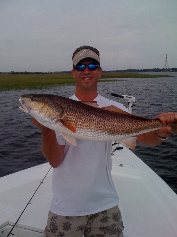 A man on a boat holding a large fish