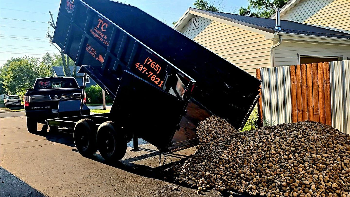 A dump truck is being towed by a truck on a trailer.