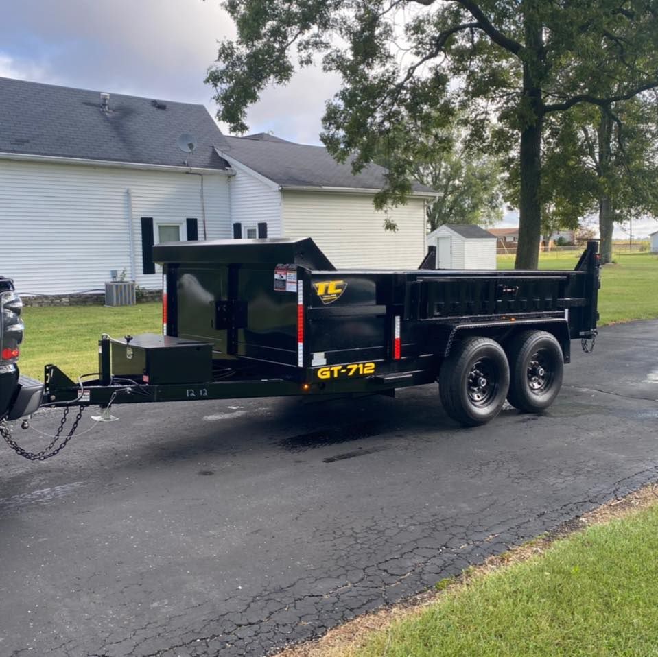 A black dump trailer with gt-712 written on the side
