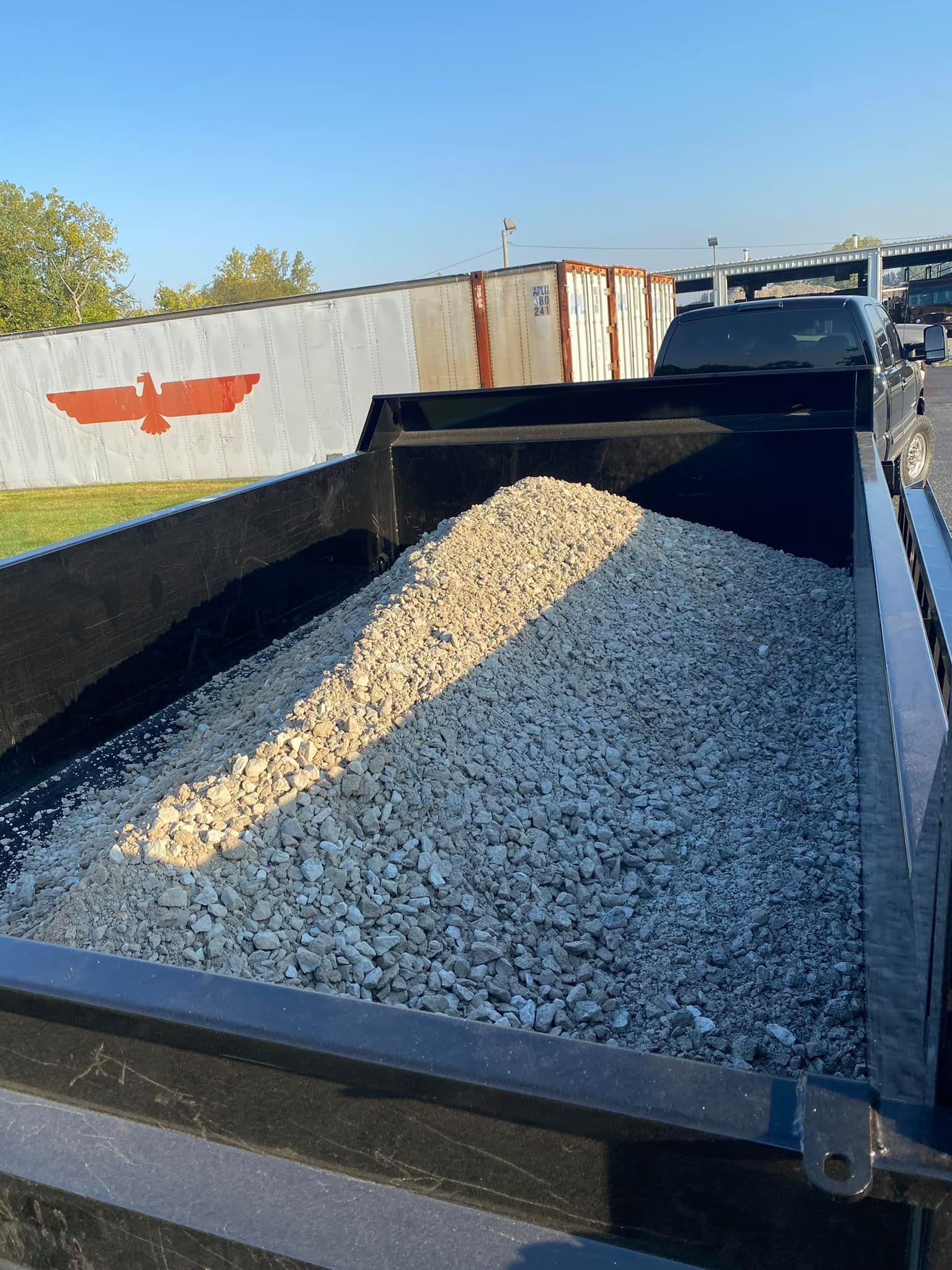 A trailer filled with wood is parked on the side of the road.
