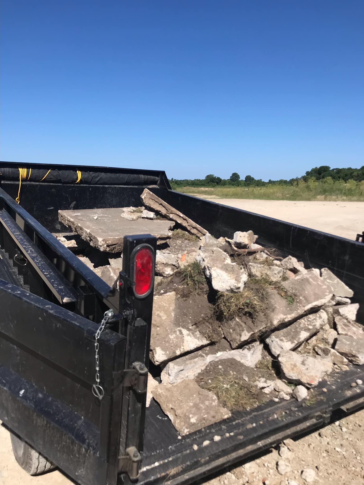 A dump truck filled with rocks is parked on the side of the road.