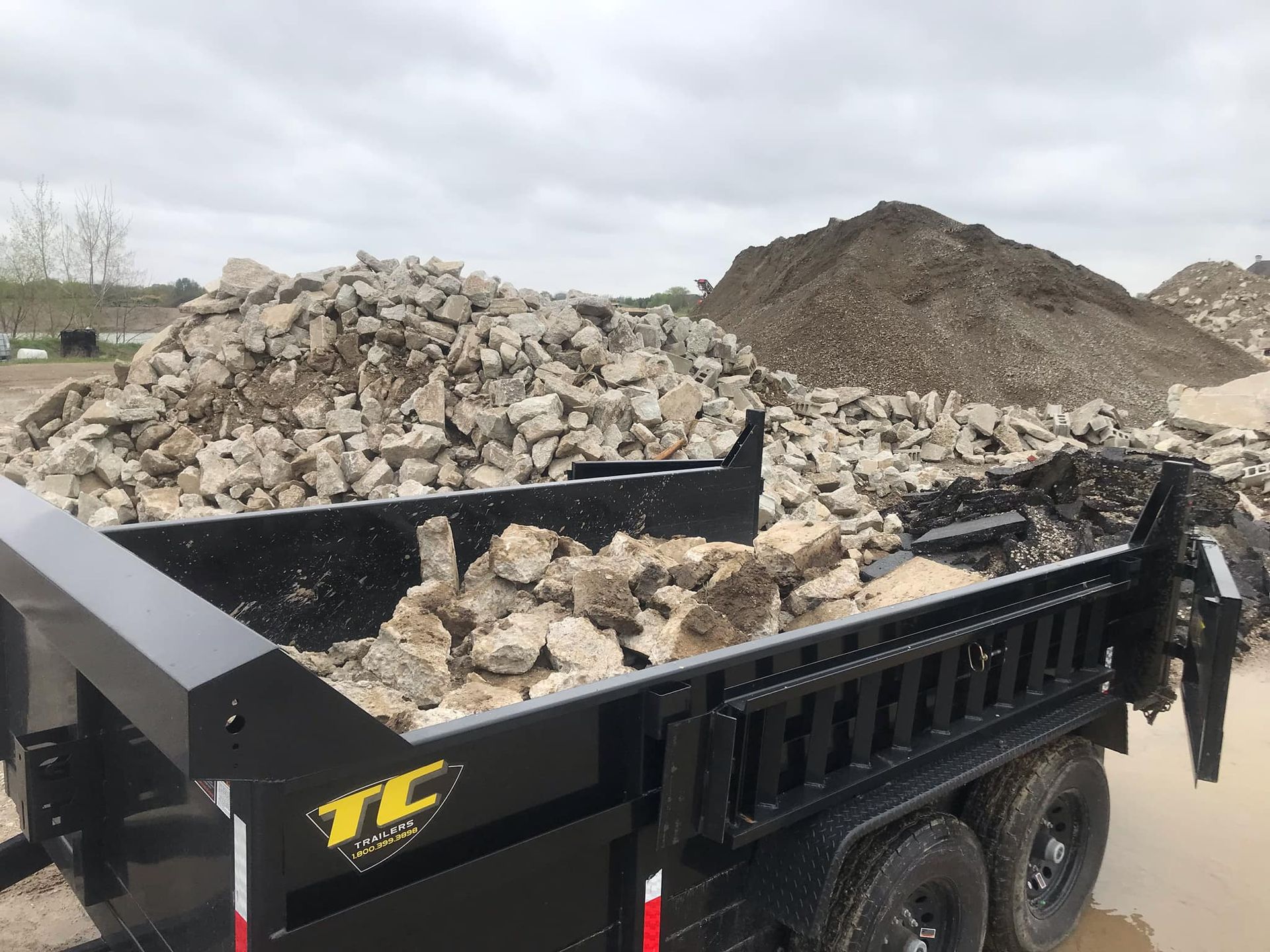 A dump truck is filled with rocks and dirt.
