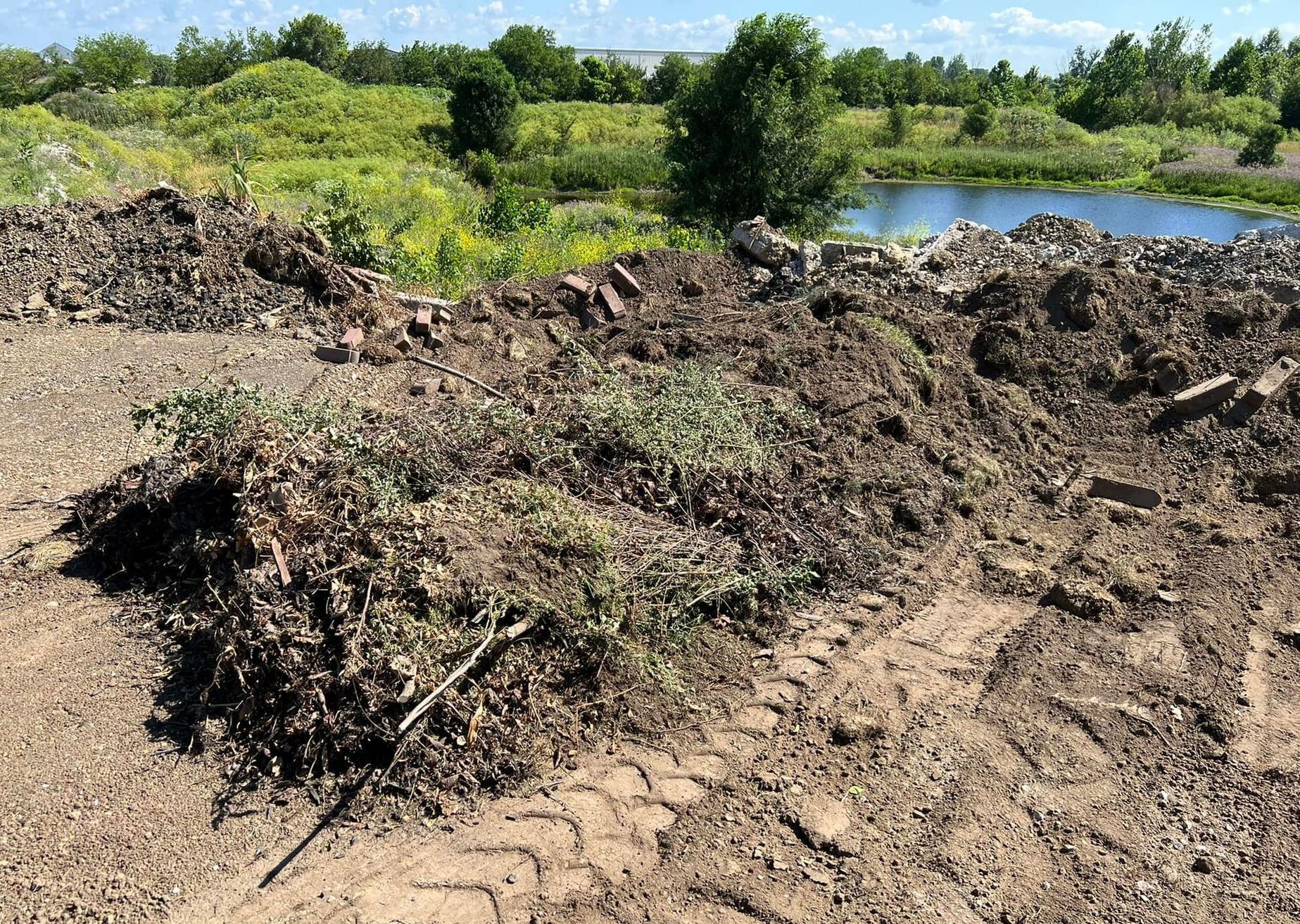 There is a large pile of dirt in the middle of a field.