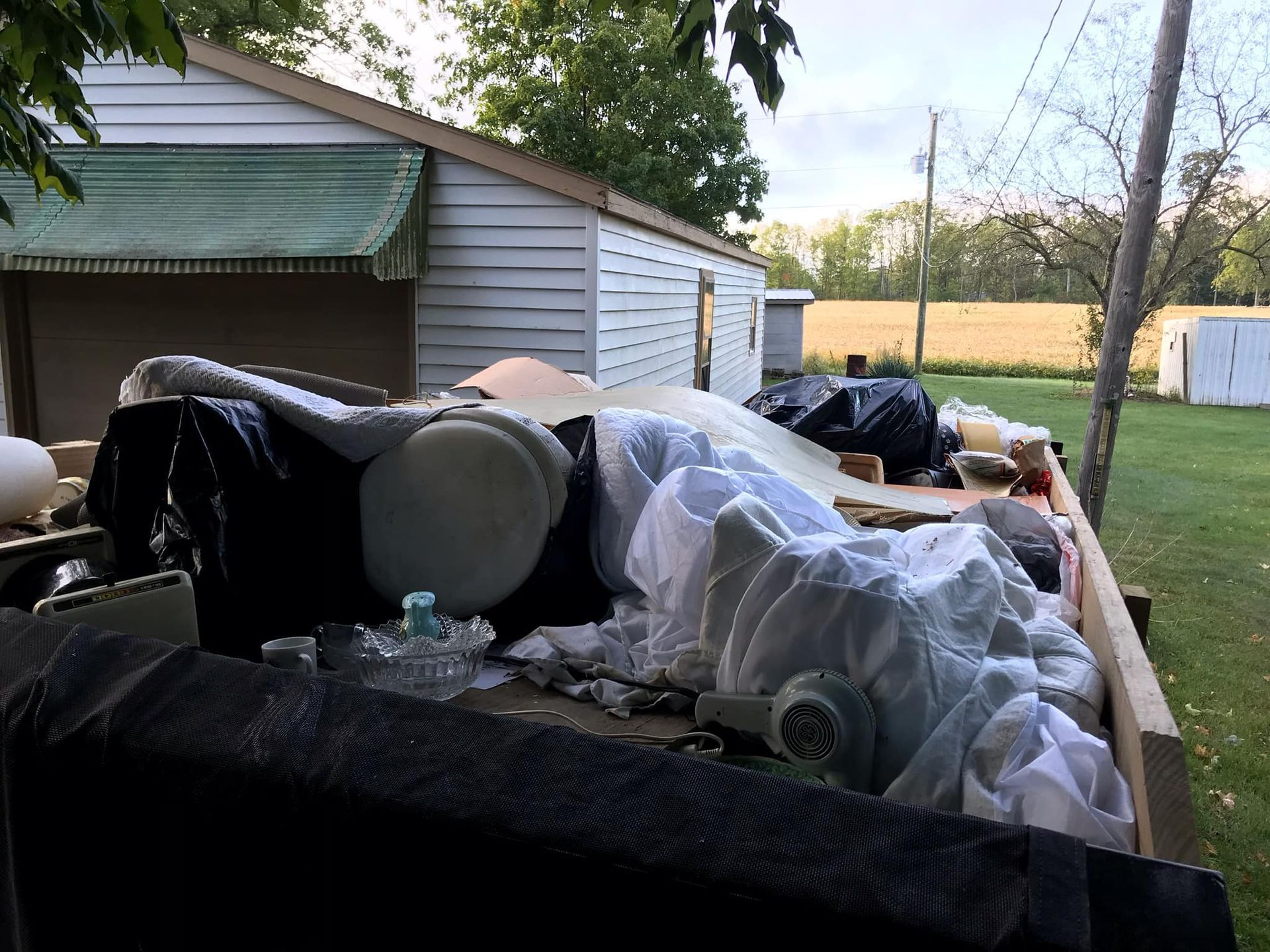A pile of trash is sitting in front of a house.