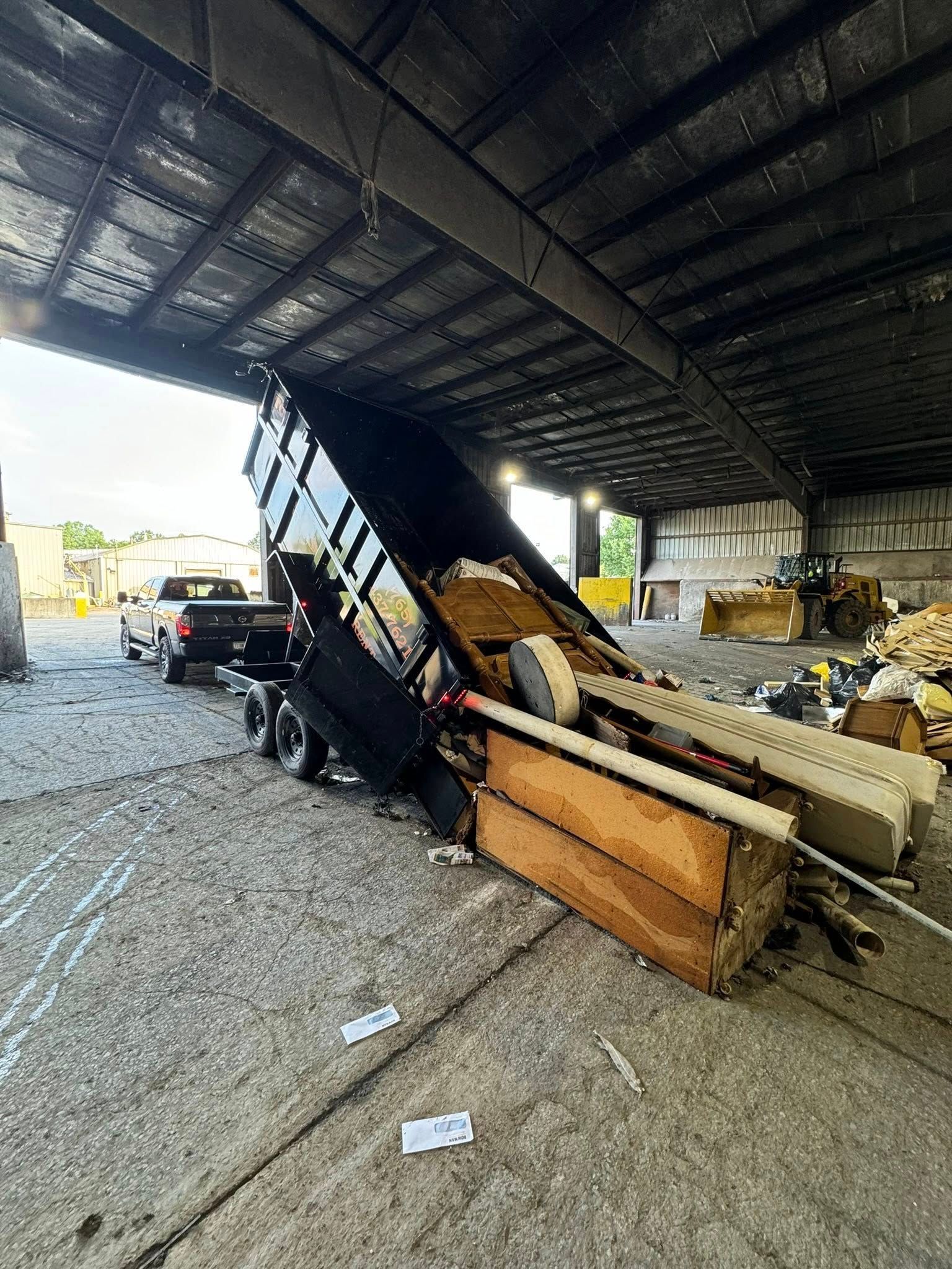 A dump truck is loading junk into a warehouse.