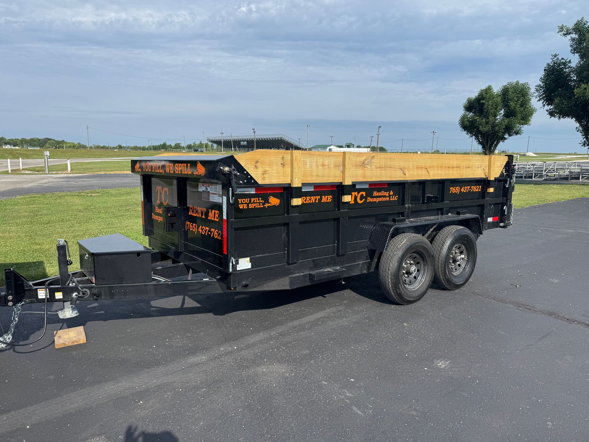A dump truck is parked in front of a white house.