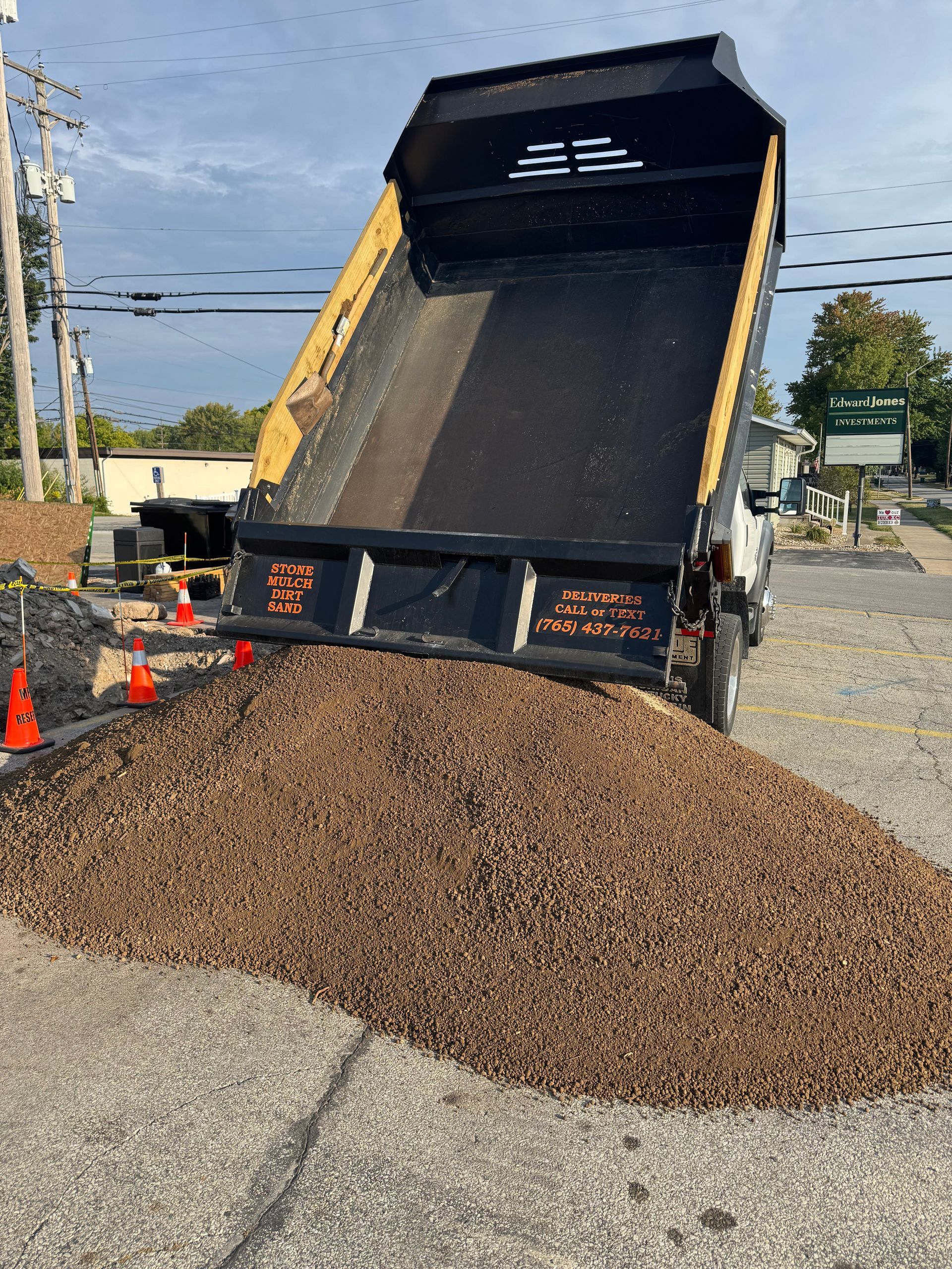 A dumpster filled with dirt is sitting on top of a dirt field.