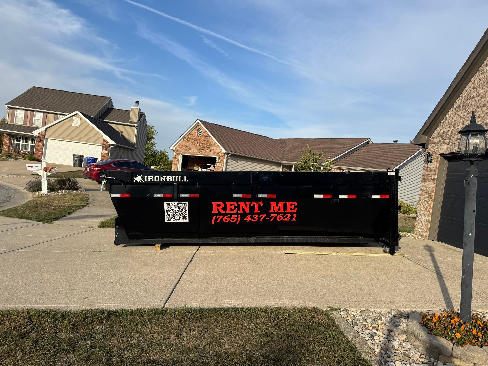 A black dumpster labeled 