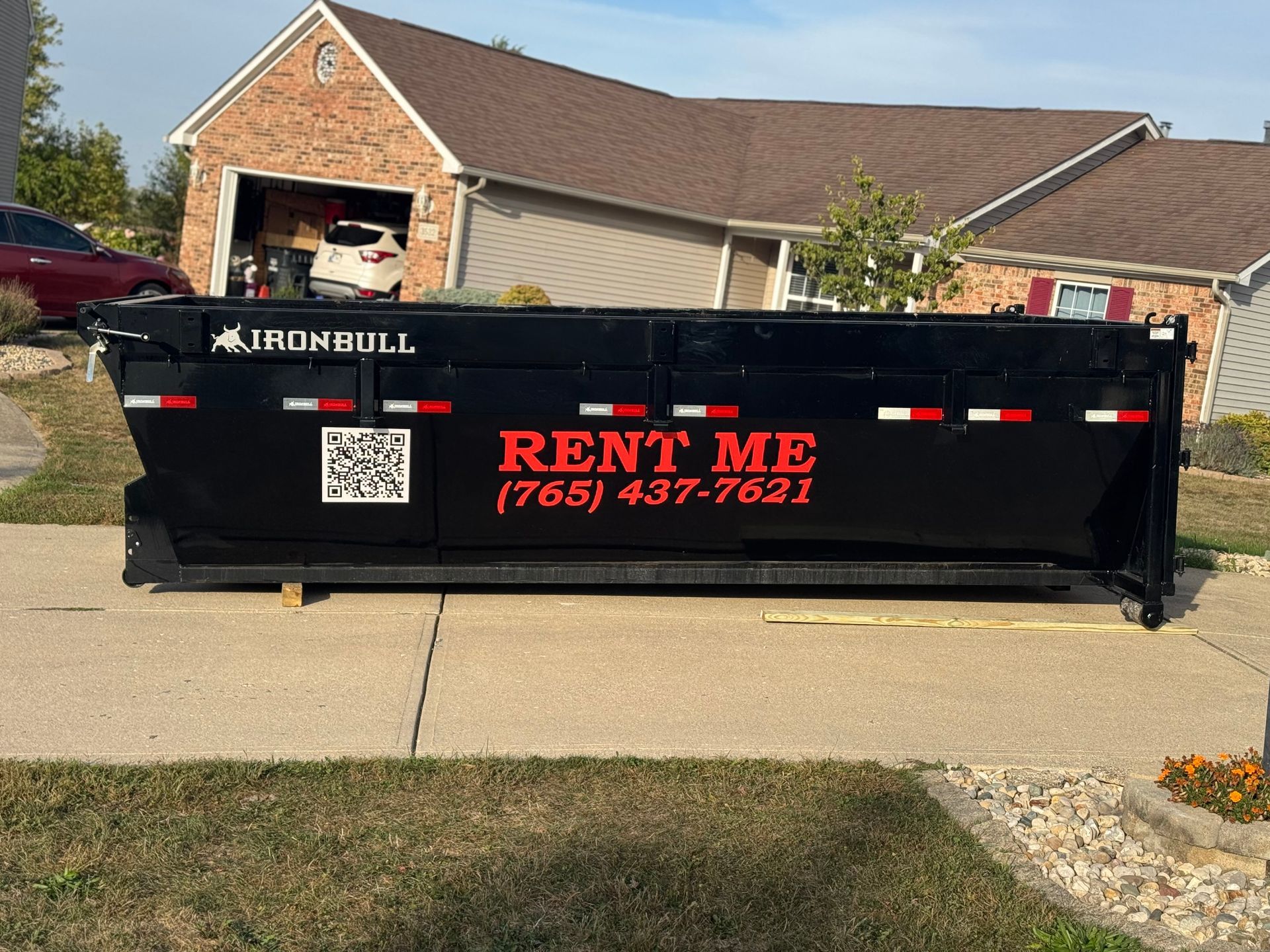 A dumpster is sitting on top of a pile of wood.