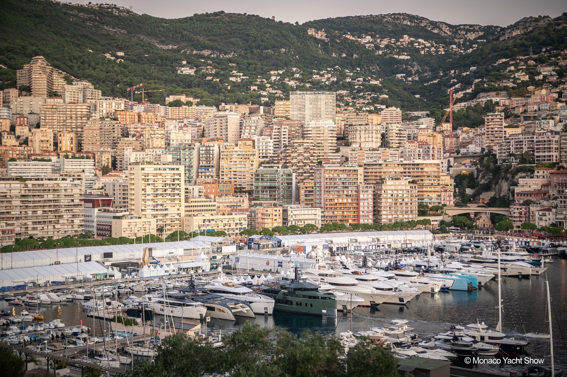 Harbor filled with yachts, city buildings on hillside, Monaco.