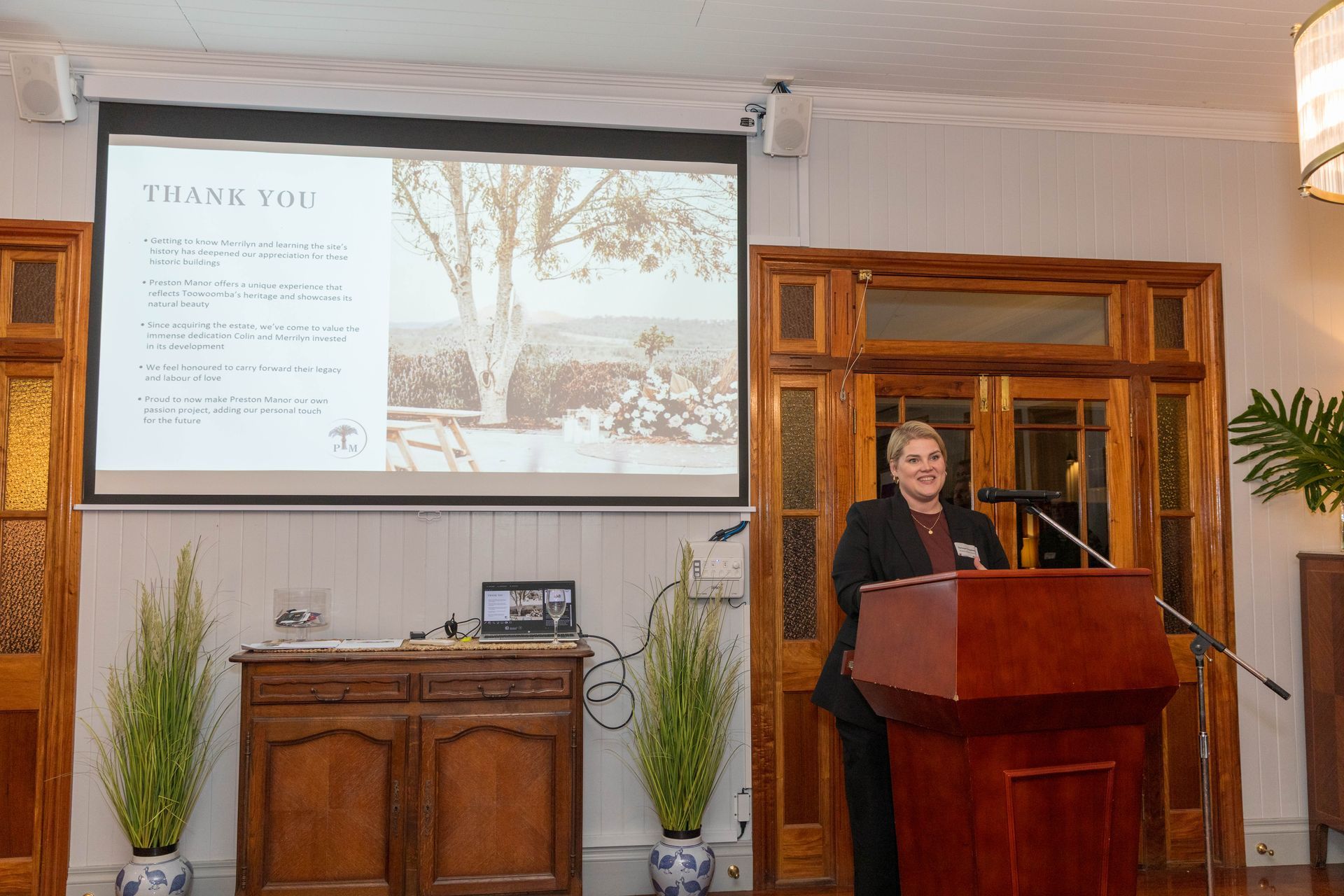 Woman giving a presentation at a podium, with a 