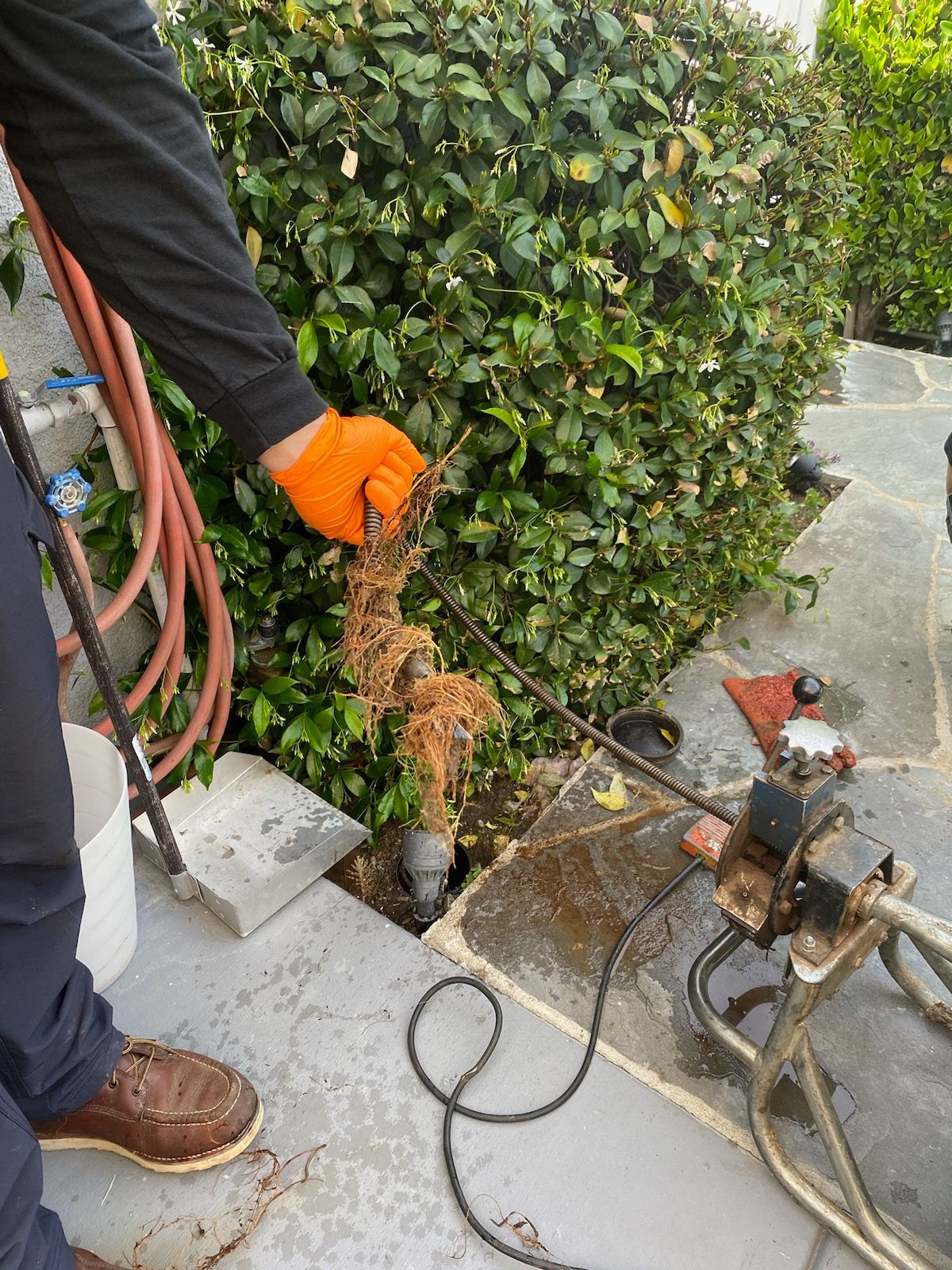 A man is using a machine to remove a drain pipe.