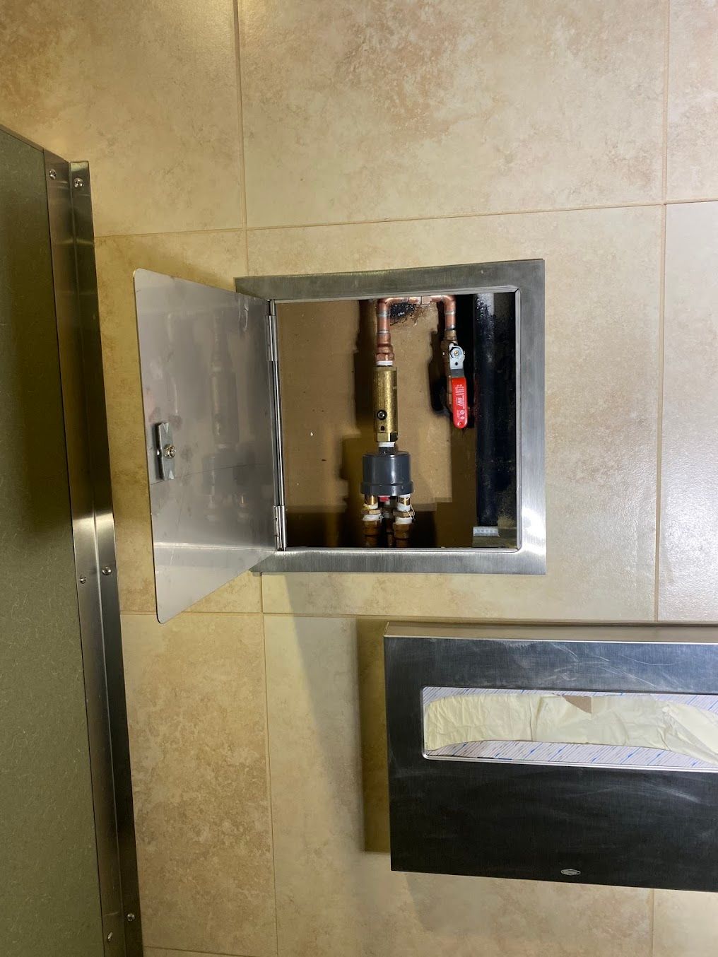 A bathroom with a stainless steel door and a stainless steel box.