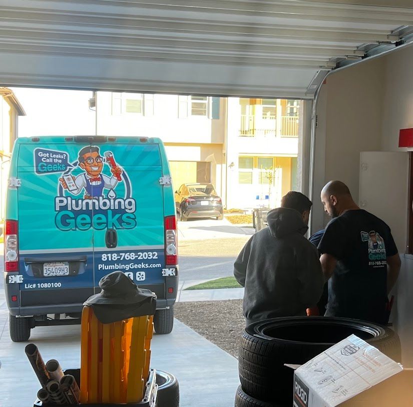 A plumbing geek van is parked in a garage