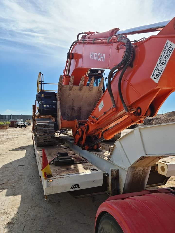 A Large Orange Excavator Is Sitting On Top Of A Trailer — Equiptranz In Kybong, QLD