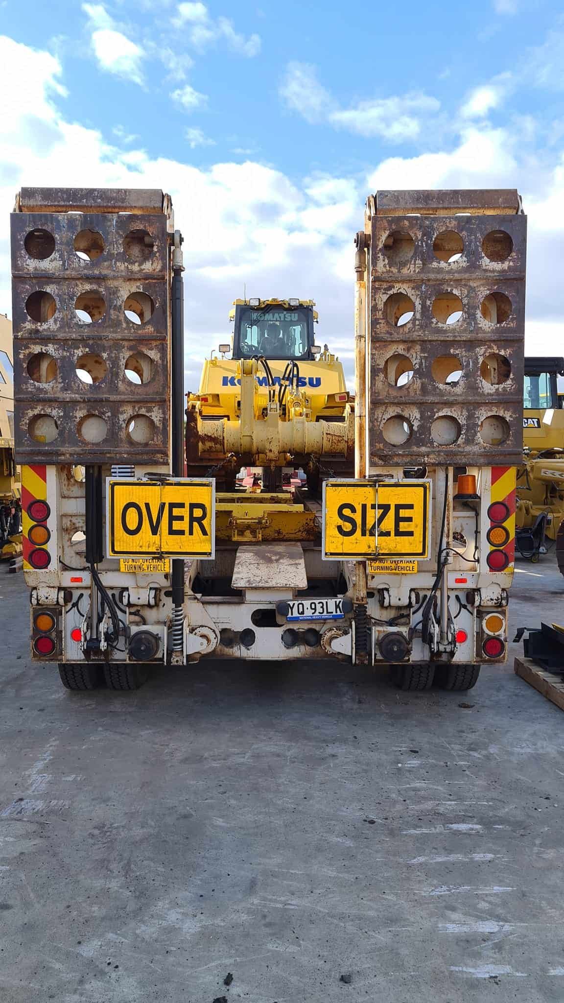 A Truck With A Bulldozer On The Back Is Parked In A Parking Lot — Equiptranz In Kybong, QLD