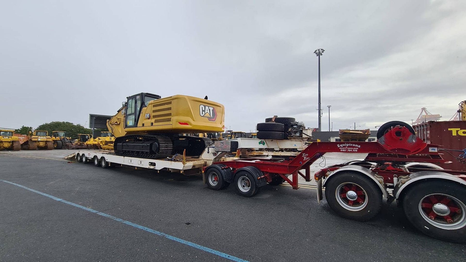 A Bulldozer Is Being Towed By A Semi Truck In A Parking Lot — Equiptranz In Kybong, QLD
