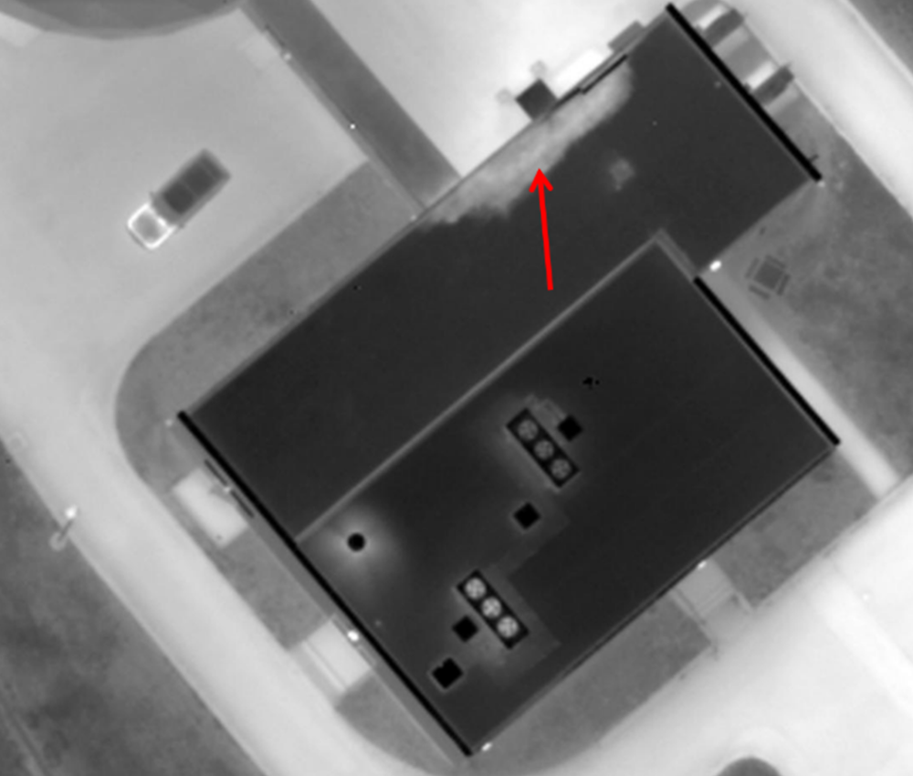 An aerial view of a building with a red arrow pointing to the roof